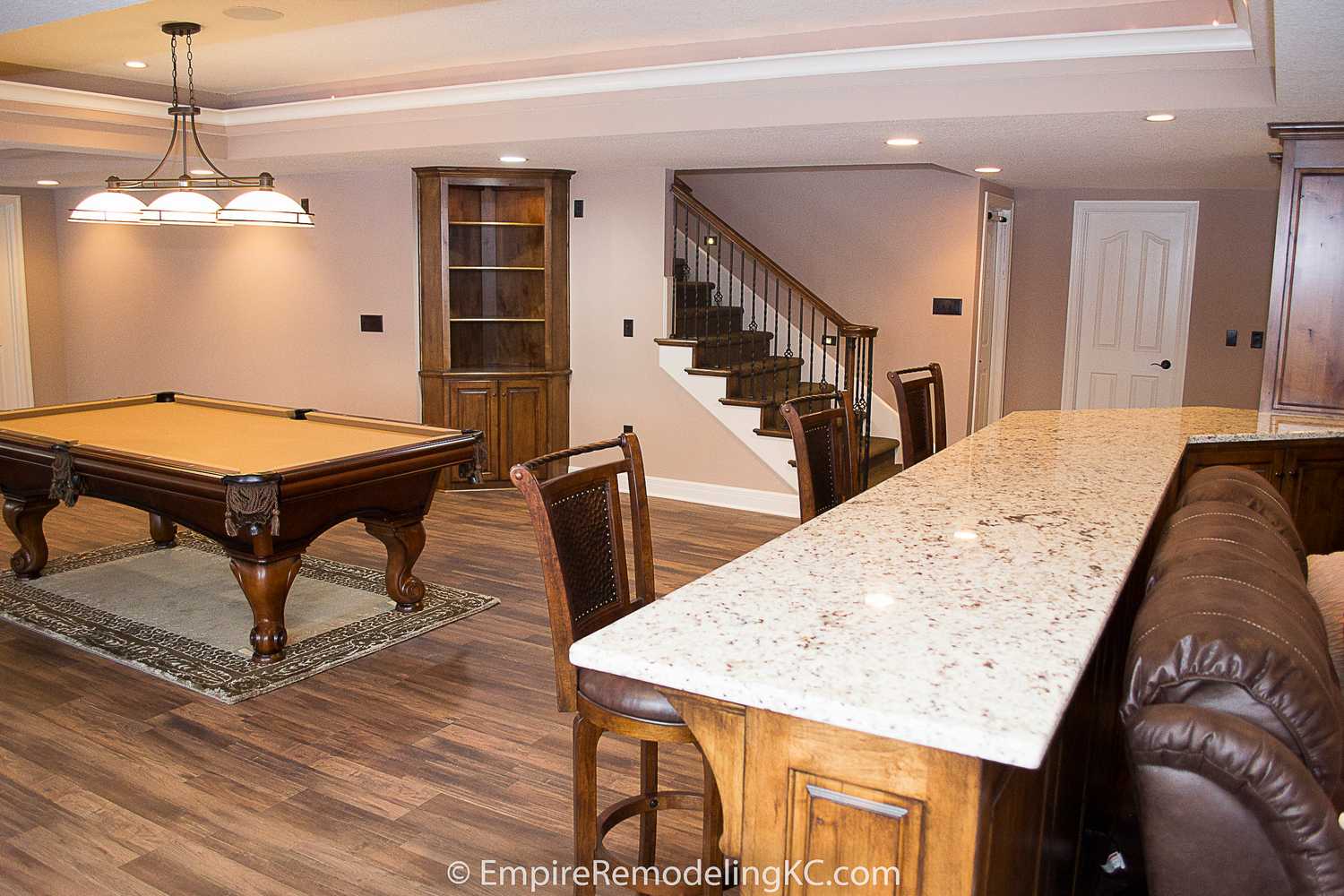 Deluxe Kitchen in Basement remodel with crawford ceilings, hidden doors, stone and granite bar, and living area.