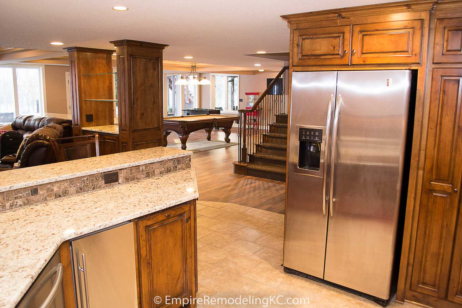 Deluxe Kitchen in Basement remodel with crawford ceilings, hidden doors, stone and granite bar, and living area.