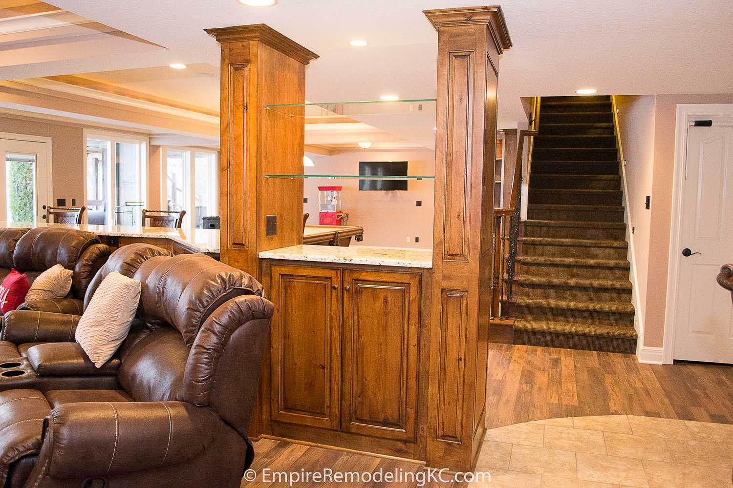 Deluxe Kitchen in Basement remodel with crawford ceilings, hidden doors, stone and granite bar, and living area.