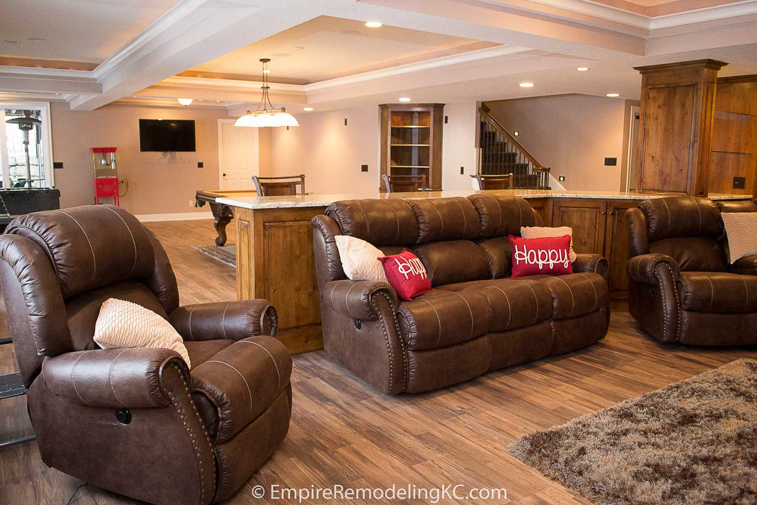 Deluxe Kitchen in Basement remodel with crawford ceilings, hidden doors, stone and granite bar, and living area.