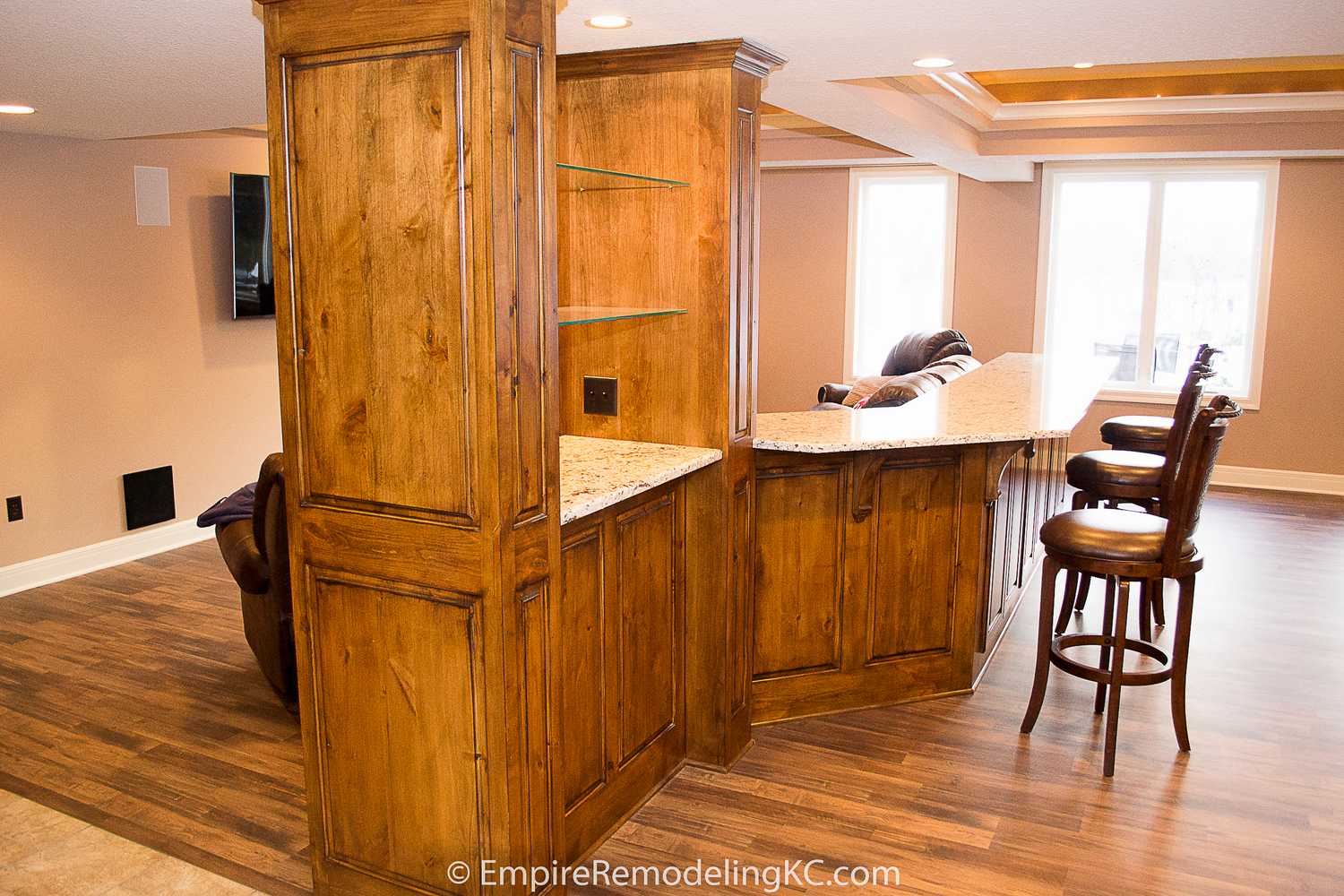 Deluxe Kitchen in Basement remodel with crawford ceilings, hidden doors, stone and granite bar, and living area.