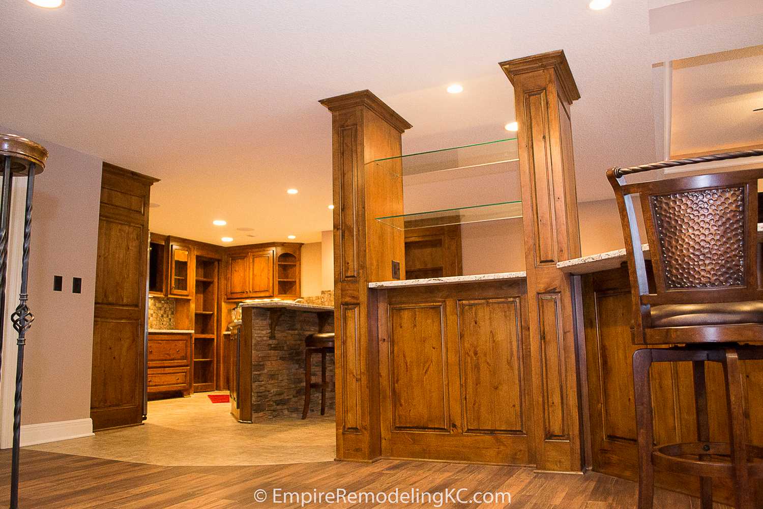 Deluxe Kitchen in Basement remodel with crawford ceilings, hidden doors, stone and granite bar, and living area.