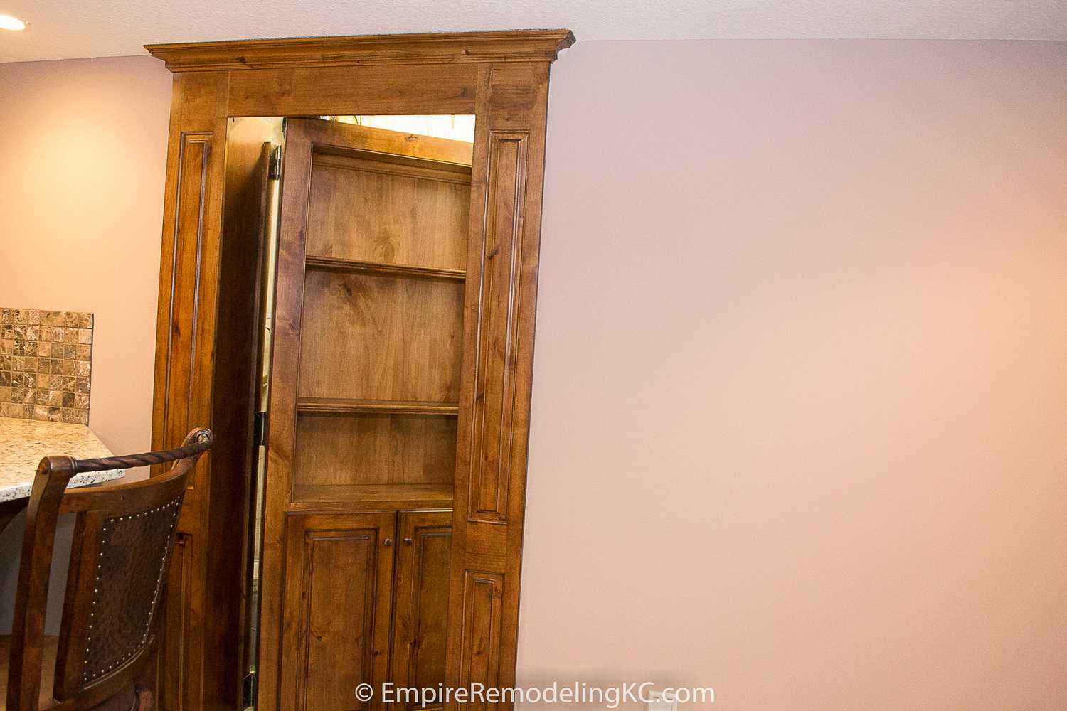 Deluxe Kitchen in Basement remodel with crawford ceilings, hidden doors, stone and granite bar, and living area.