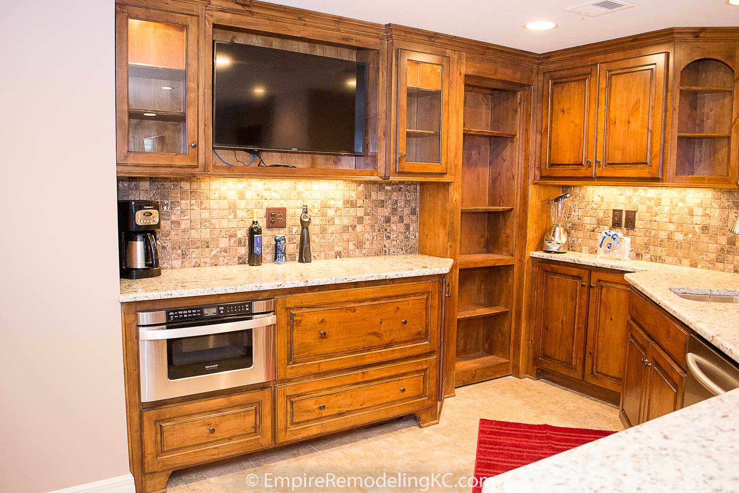 Deluxe Kitchen in Basement remodel with crawford ceilings, hidden doors, stone and granite bar, and living area.