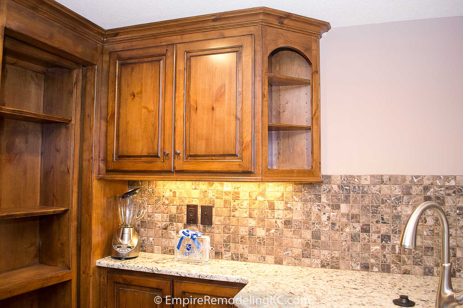 Deluxe Kitchen in Basement remodel with crawford ceilings, hidden doors, stone and granite bar, and living area.