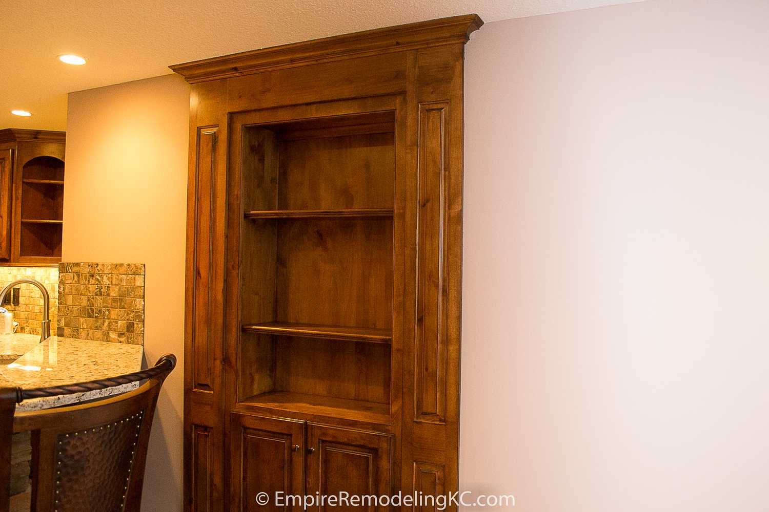 Deluxe Kitchen in Basement remodel with crawford ceilings, hidden doors, stone and granite bar, and living area.