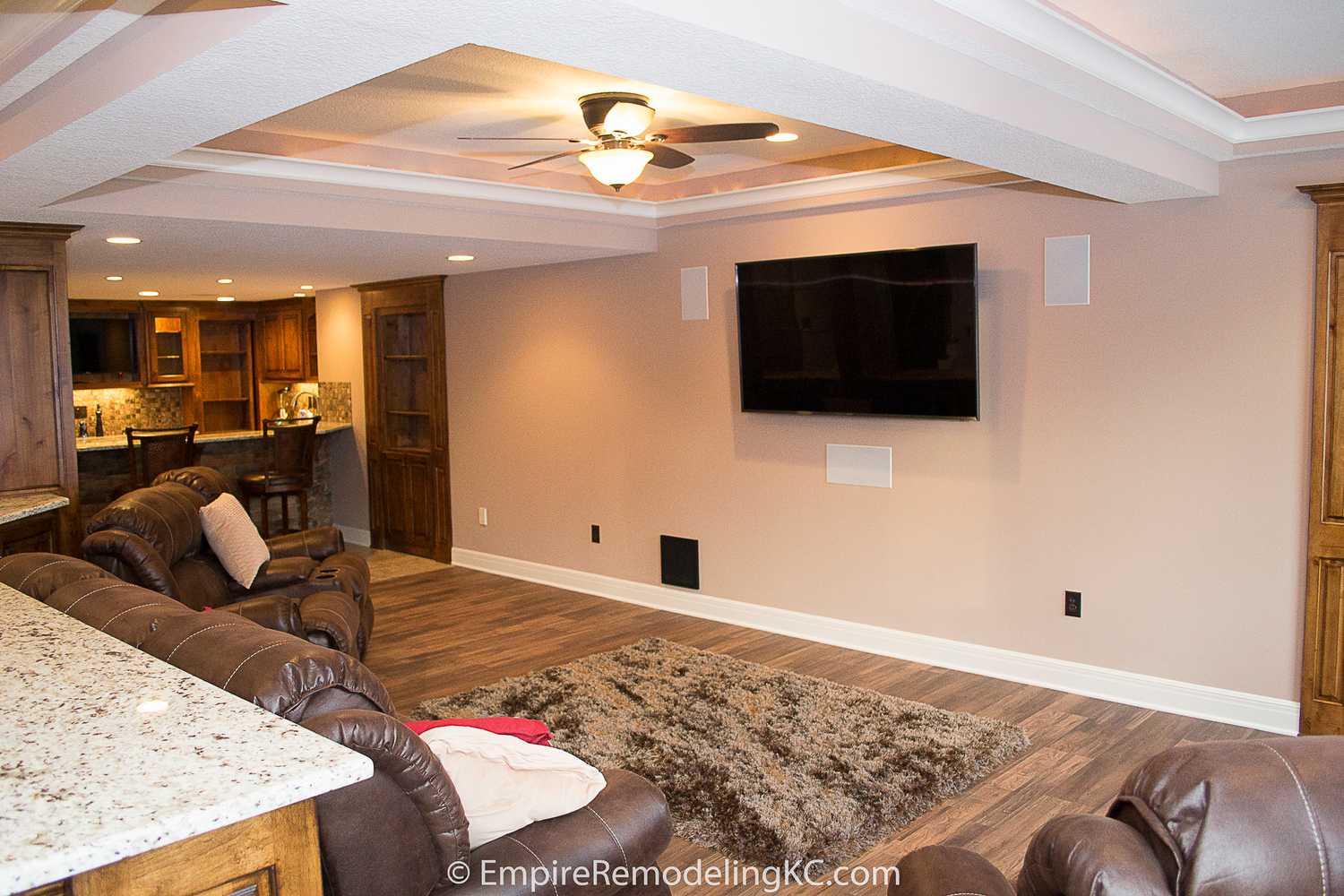 Deluxe Kitchen in Basement remodel with crawford ceilings, hidden doors, stone and granite bar, and living area.