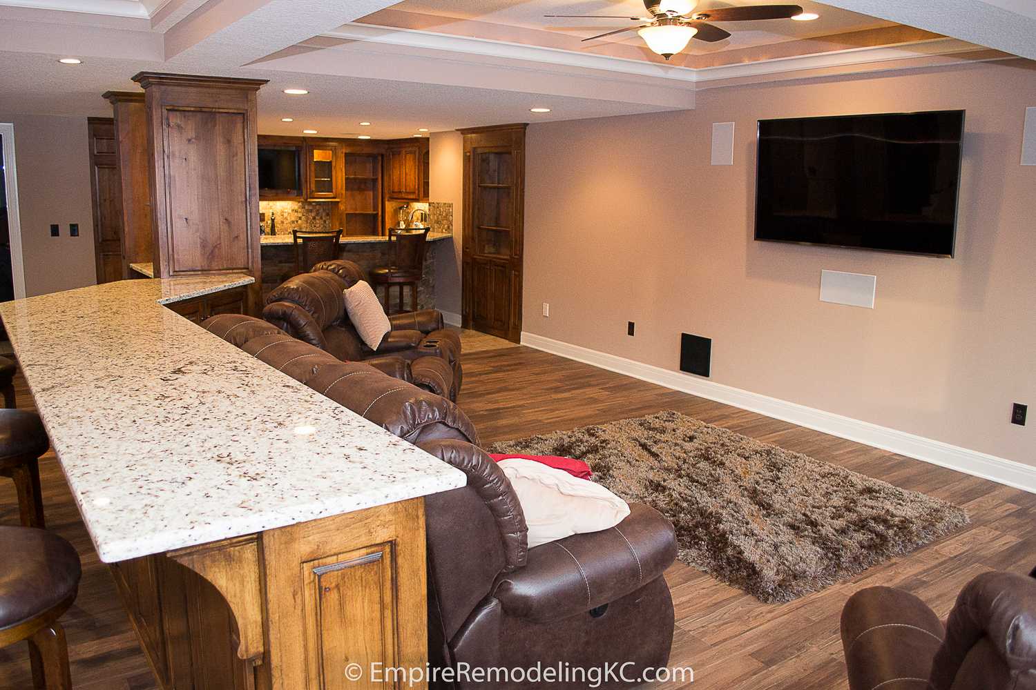 Deluxe Kitchen in Basement remodel with crawford ceilings, hidden doors, stone and granite bar, and living area.