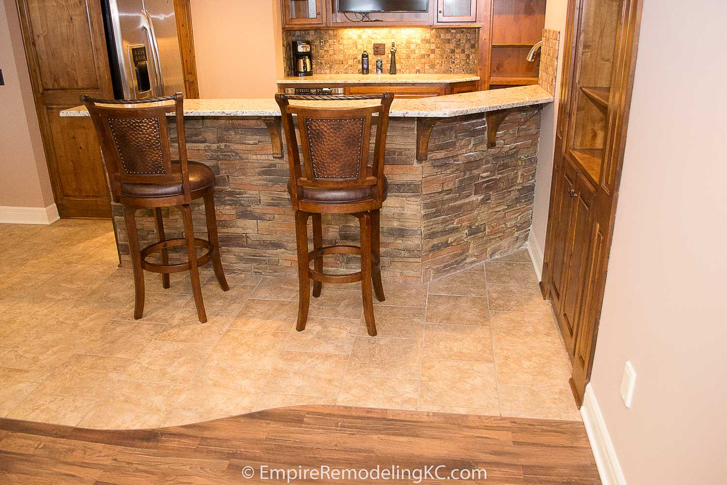 Deluxe Kitchen in Basement remodel with crawford ceilings, hidden doors, stone and granite bar, and living area.