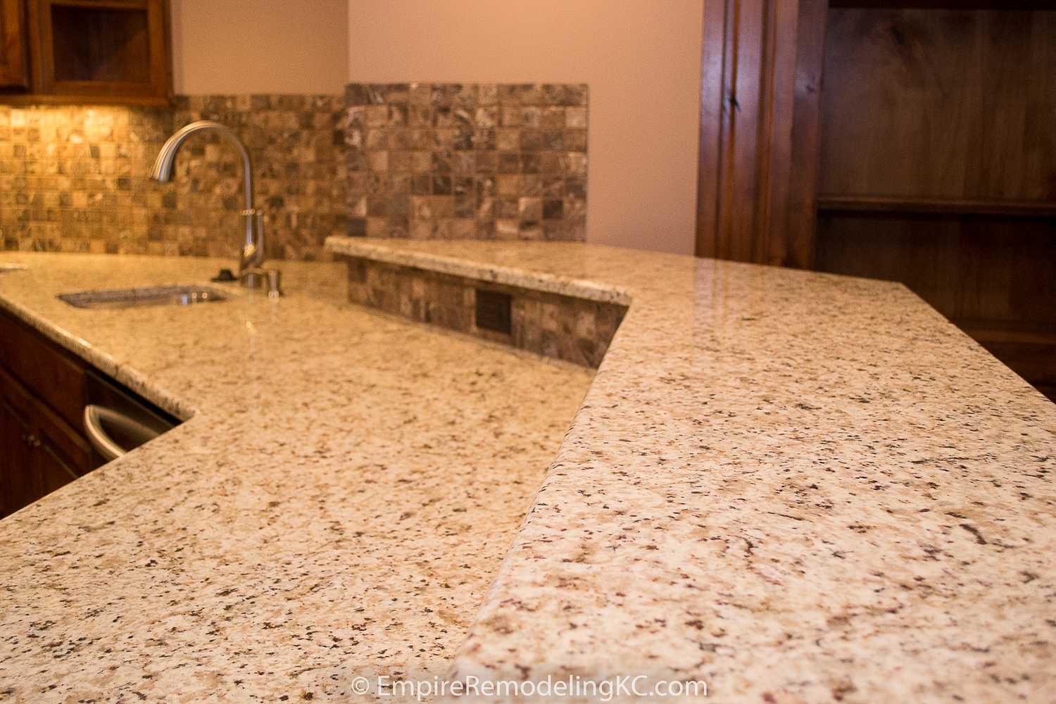 Deluxe Kitchen in Basement remodel with crawford ceilings, hidden doors, stone and granite bar, and living area.