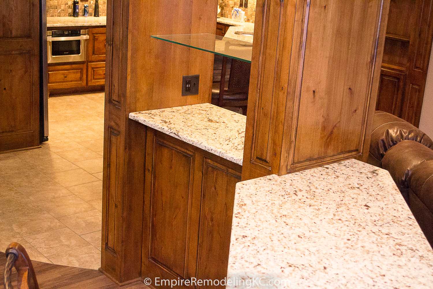 Deluxe Kitchen in Basement remodel with crawford ceilings, hidden doors, stone and granite bar, and living area.