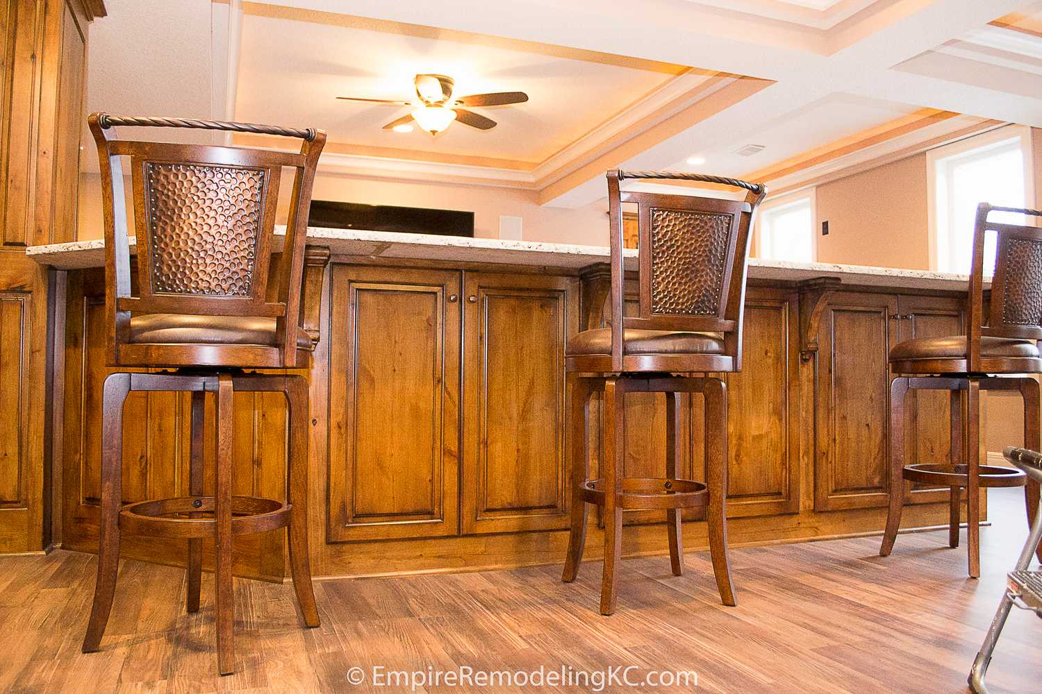 Deluxe Kitchen in Basement remodel with crawford ceilings, hidden doors, stone and granite bar, and living area.