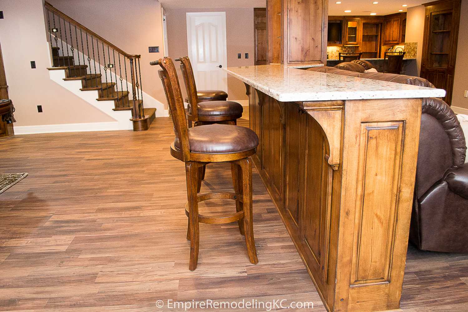 Deluxe Kitchen in Basement remodel with crawford ceilings, hidden doors, stone and granite bar, and living area.