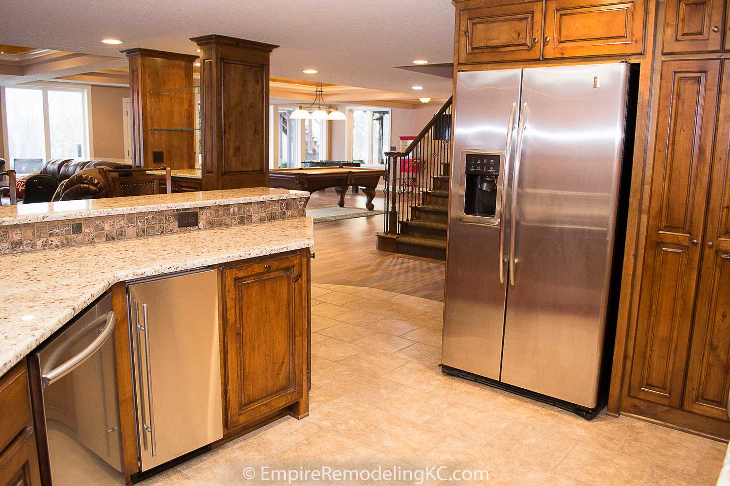 Deluxe Kitchen in Basement remodel with crawford ceilings, hidden doors, stone and granite bar, and living area.