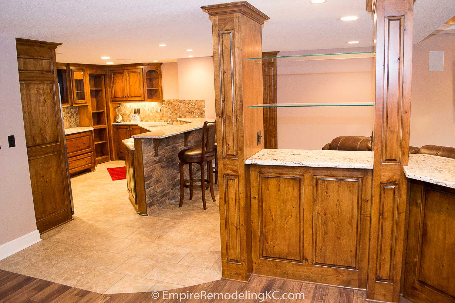 Deluxe Kitchen in Basement remodel with crawford ceilings, hidden doors, stone and granite bar, and living area.