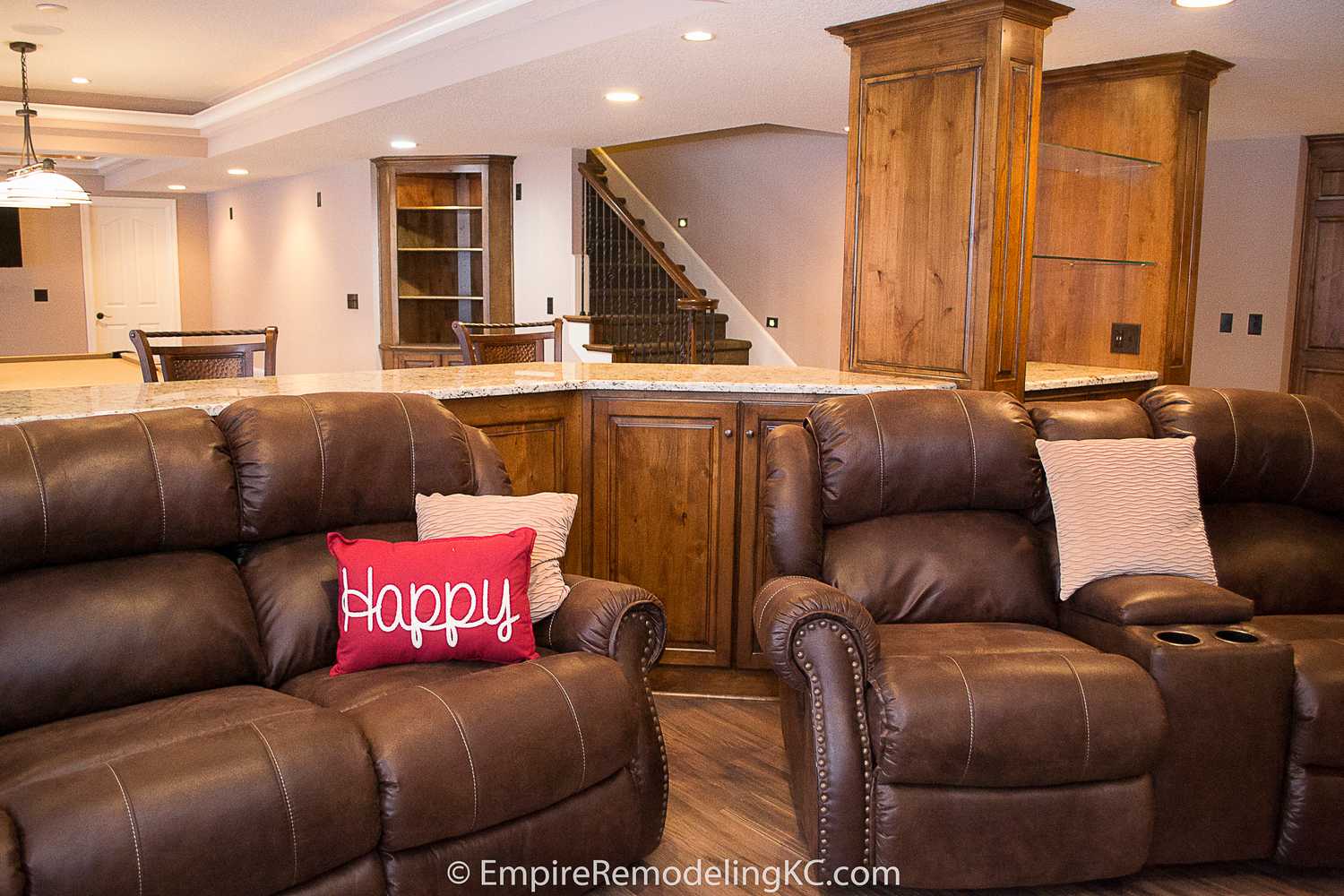 Deluxe Kitchen in Basement remodel with crawford ceilings, hidden doors, stone and granite bar, and living area.