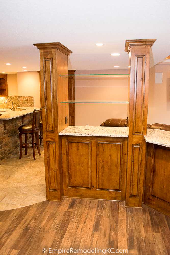 Deluxe Kitchen in Basement remodel with crawford ceilings, hidden doors, stone and granite bar, and living area.