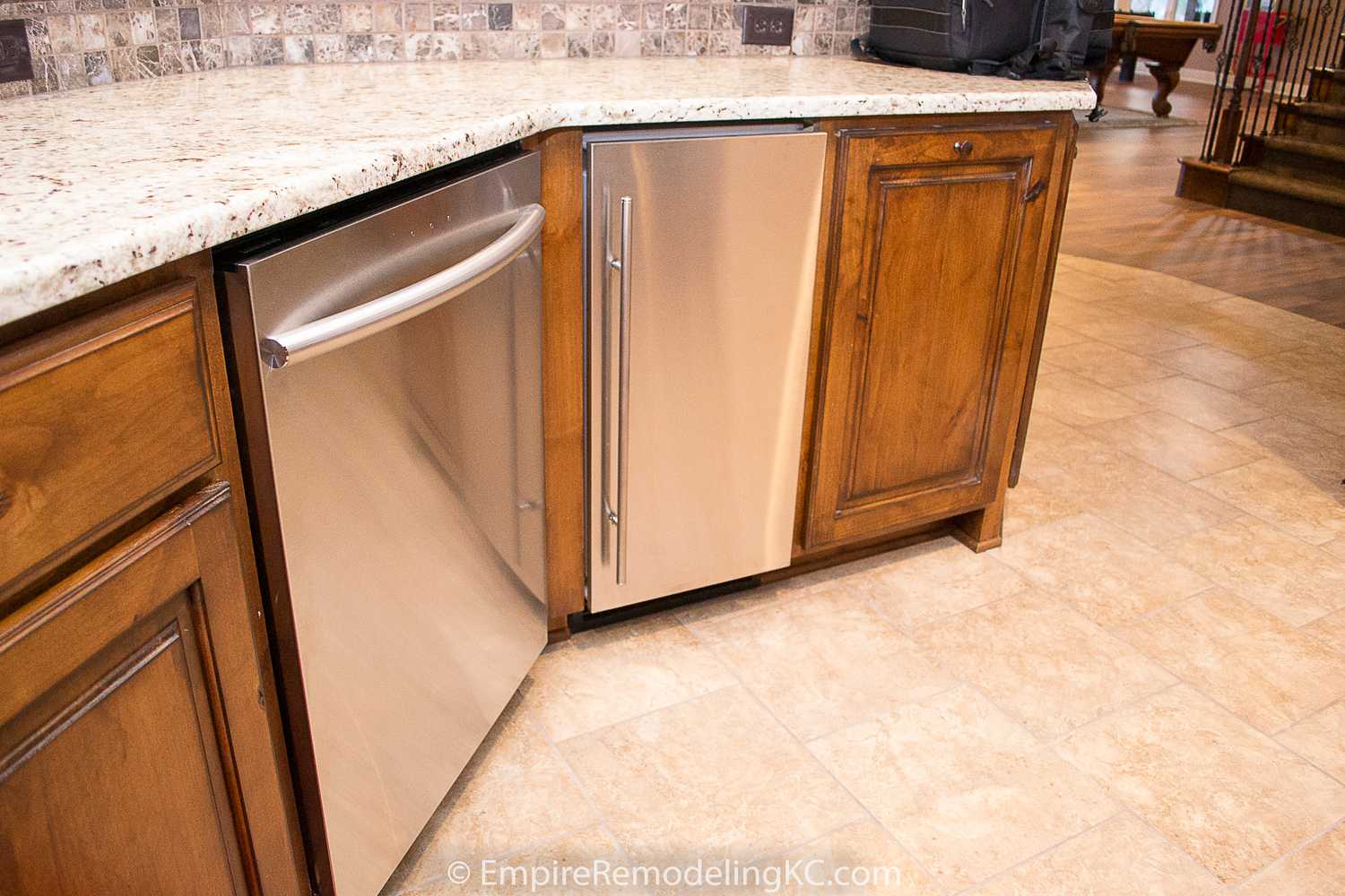 Deluxe Kitchen in Basement remodel with crawford ceilings, hidden doors, stone and granite bar, and living area.