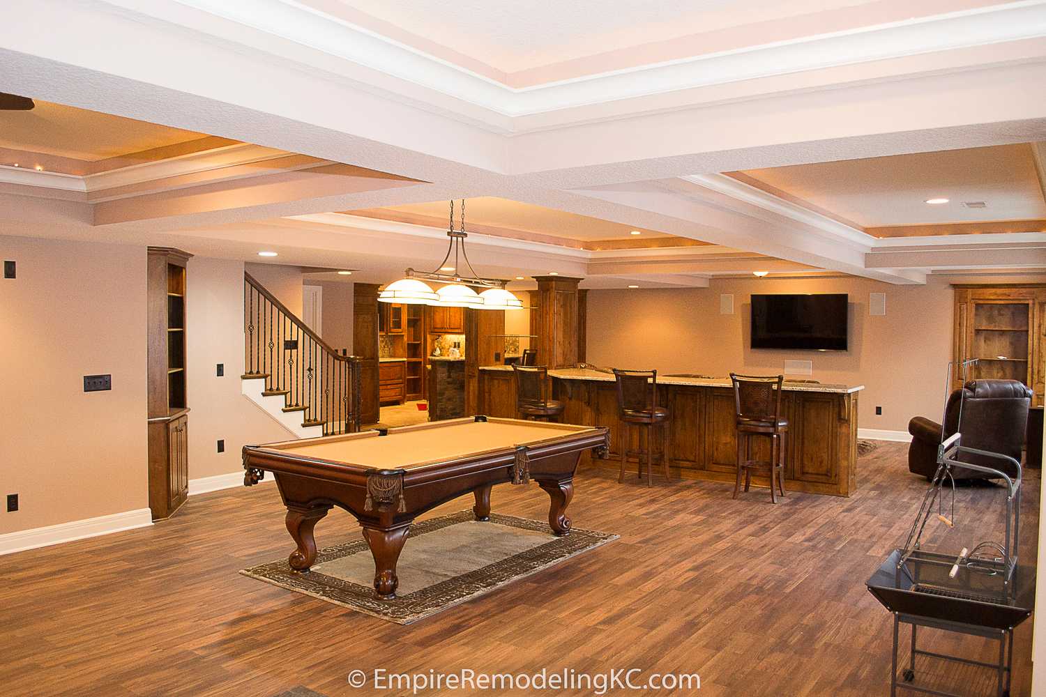 Deluxe Kitchen in Basement remodel with crawford ceilings, hidden doors, stone and granite bar, and living area.