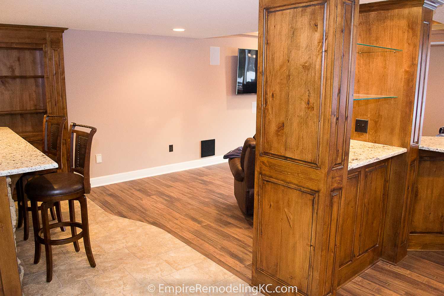 Deluxe Kitchen in Basement remodel with crawford ceilings, hidden doors, stone and granite bar, and living area.