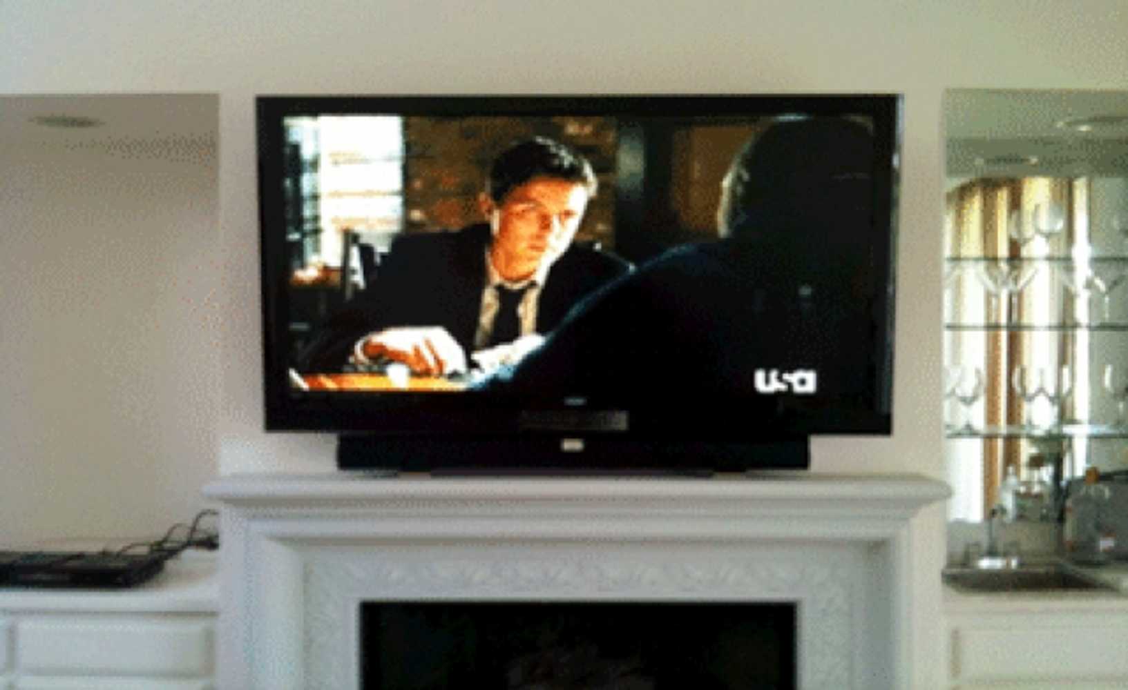 65 inch TV and soundbar mounted over fireplace