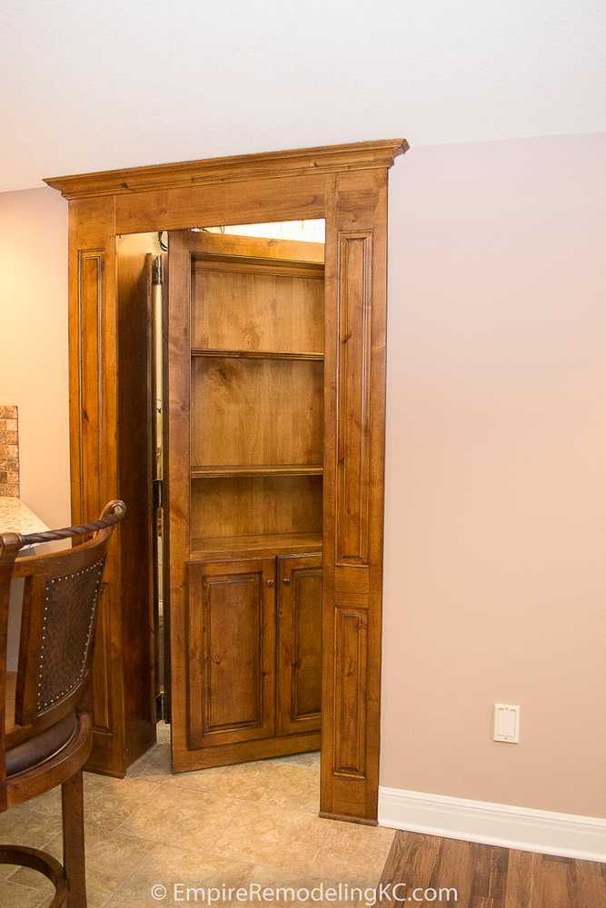 Deluxe Kitchen in Basement remodel with crawford ceilings, hidden doors, stone and granite bar, and living area.