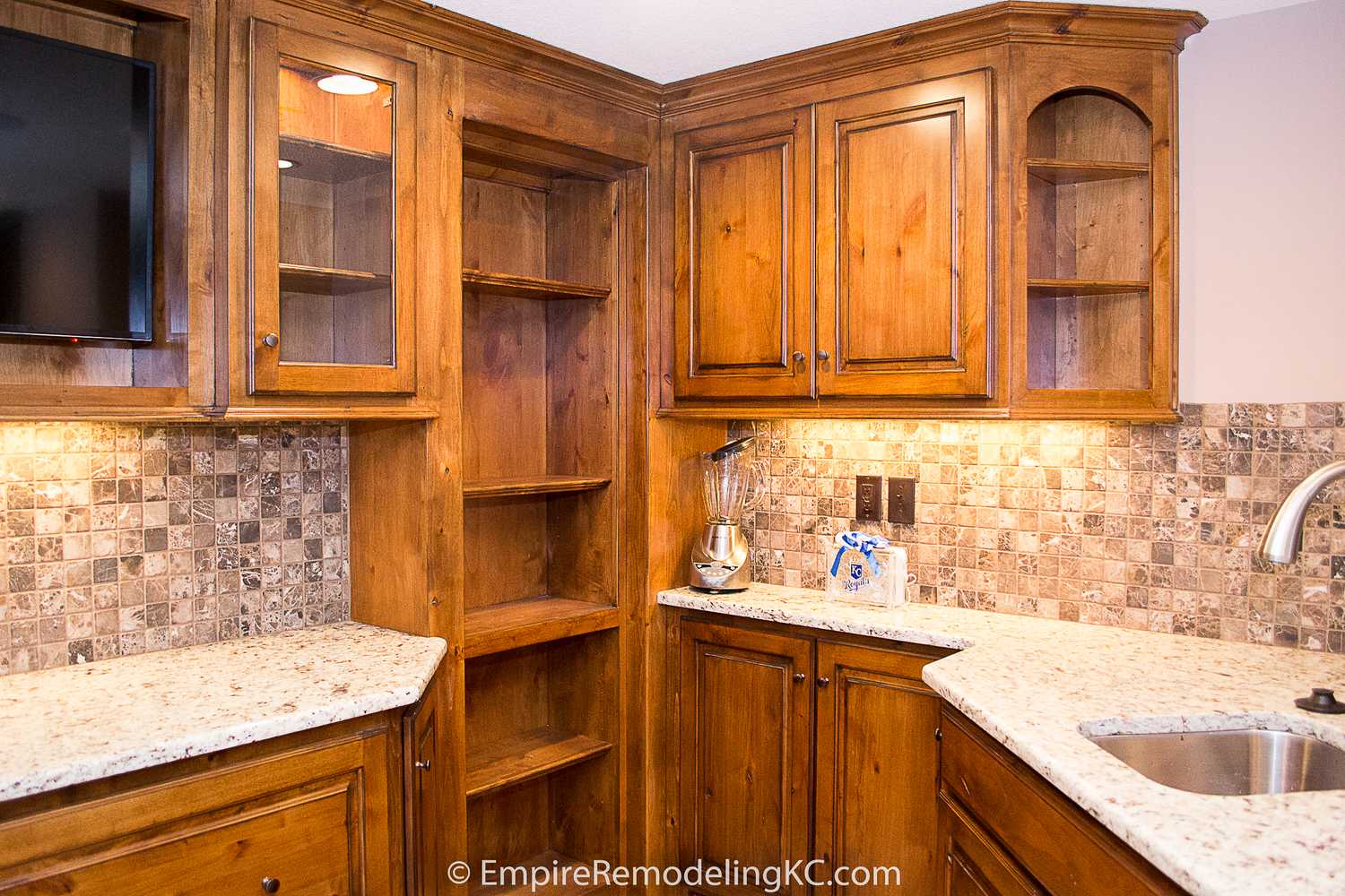 Deluxe Kitchen in Basement remodel with crawford ceilings, hidden doors, stone and granite bar, and living area.