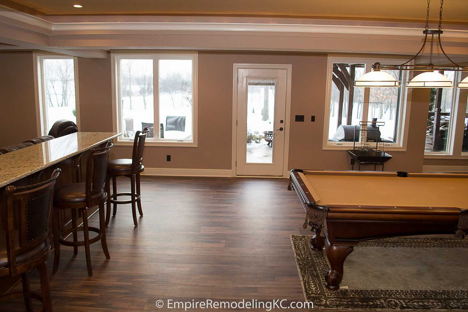 Deluxe Kitchen in Basement remodel with crawford ceilings, hidden doors, stone and granite bar, and living area.