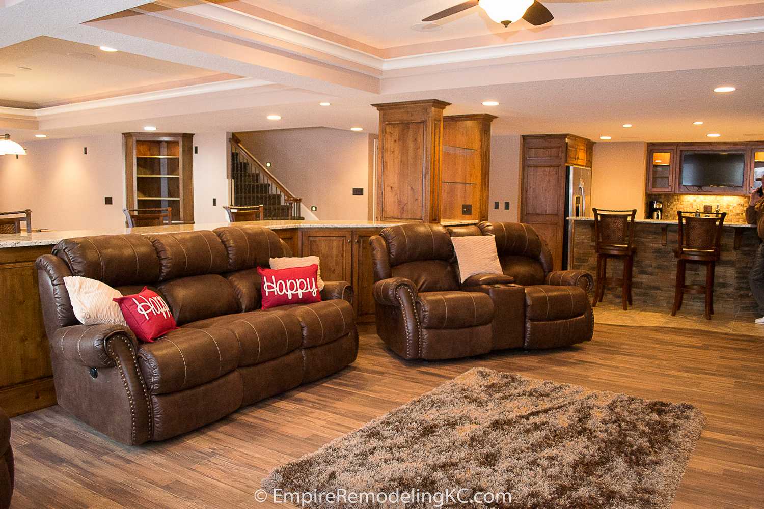 Deluxe Kitchen in Basement remodel with crawford ceilings, hidden doors, stone and granite bar, and living area.